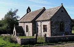 A simple stone church with a bellcote, seen from the southeast