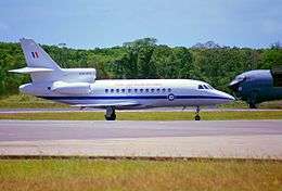 Trijet passenger plane on runway, with nose of another aircraft in background