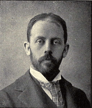 Head of a man in his thirties with closely trimmed hair and beard