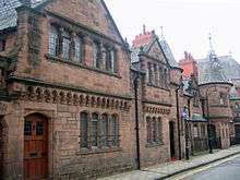 A row of stone houses with two storeys and a turret at the far end.