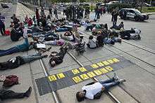 Protesters lying down over rail tracks with a "Black Lives Matter" banner.