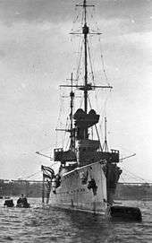 A large ship moored to a buoy with a small boat alongside