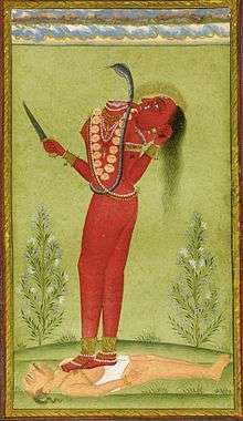 A decapitated, nude, red-complexioned woman stands on a man lying on the ground. She holds in her left hand her severed hand that drinks the blood jet sprouting from her neck. She holds a knife in her other hand. She wears a serpent across her torso and various gold and pearl ornaments.