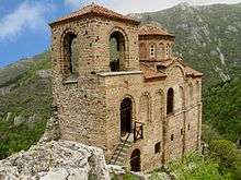 Southwest view of a two-storied medieval church in a mountainous area