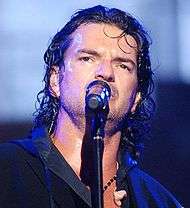 Ricardo Arjona, singing into a microphone