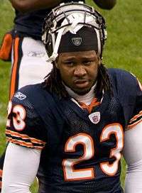 A dark-skinned man wearing a blue football jersey with a number 23