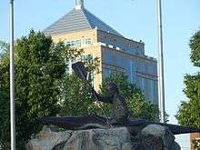 Highway 52 crossing the Wisconsin River, with a kayaking statue in the park and the Dudley Tower in the background