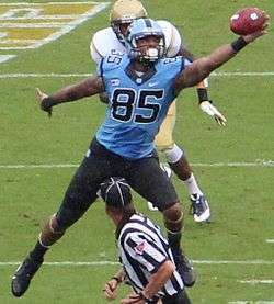 An American football player catching a football in mid-air.