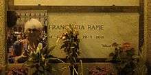 A marble gravestone on the wall of a crypt