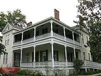 A two story light yellow plantation home