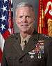 A color image of James Amos, a white male in his Marine Corps Service A uniform. He is not wearing a hat, several ribbons are visible as well as a rifle and pistol marksmanship badges and naval aviator insignia. The Marine Corps flag and United States flag are visible in the background.