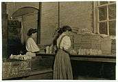 Two women packing glass in factory