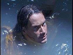 Headshot of a man in water, the water covered his whole body, only his head is visible above the water.