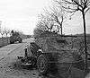 Sherman tanks passing a disabled German armoured car