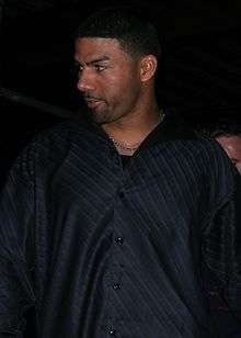 An olive-skinned man with a goatee wearing a black shirt