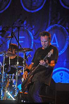 Man playing electric guitar onstage during a rock concert