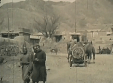 A black and white image of two men walking down a street in Kalgan, China, circa 1929.