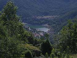 a small lake in a deep wooded valley