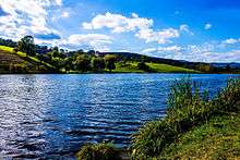 Lake with rolling, wooded hills on the opposite shore