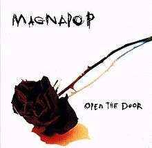 A photograph of a black rose on a stark white background with "MAGNAPOP" written at the top left and "OPEN THE DOOR" written in the bottom right in a scratchy black font.