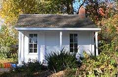 One-room wood building with two windows and small front porch