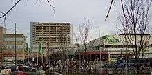 Olympia shopping mall from afar, street view, on partly cloudy winter day