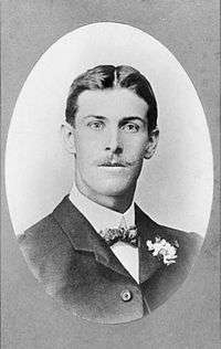 A formal head-and-shoulders portrait of a man. He is well groomed, and is wearing a suit.