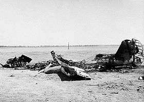 An aircraft's burnt-out wings, fuselage and tail fin