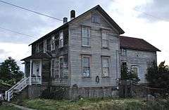 Photograph of the Larson House, an unpainted, two-story, wooden house composed of rectilinear forms