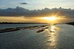 A broad river with land partially visible at each side; a narrow island separates two sides of the river