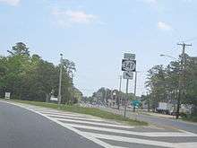 A road at a fork with a sign reading south Route 347 arrow pointing to the upper left