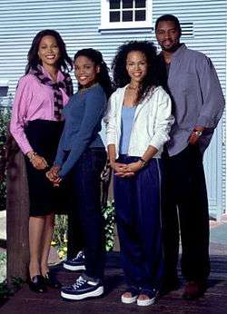 An image of an African-American family standing outside of a house.