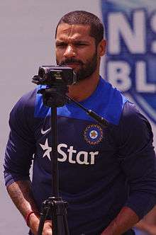 An Indian cricketer wearing a blue shirt.