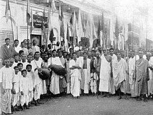 A group of India people with drums and flags in a semicircle