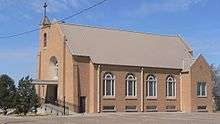 Brick church with four round-topped windows along side