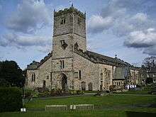The west end of a stone church with an embraced battlemented tower