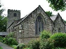 A church with two gables and a battlemented tower at the far end