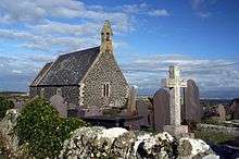 A small stone church in a graveyard.