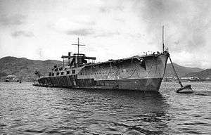 A large ship anchored and at rest near a shoreline.