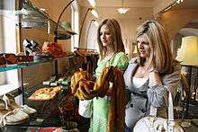 Two young women examining merchandise in a clothing store.