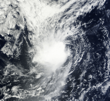 A visible satellite image showing a poorly-organized tropical storm, with its center of circulation exposed, on October 14.