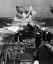 A depth charge explodes astern during a practice anti-submarine run during the ship's shakedown tests.