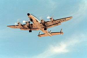 A large four-engined aircraft flying overhead during take-off