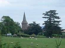 a distant view of Wolferlow church behind the green hills