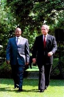 two men walking; they're wearing suits.